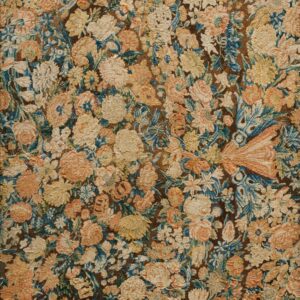 Densely textured rug featuring faded floral designs in cream, yellow, blue, and peach on a dark brown field.