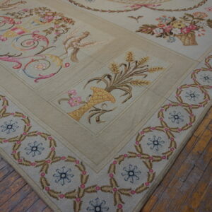 Low-pile beige rug with pink, blue, and yellow pastoral scenes and a repeating border on wood floors.