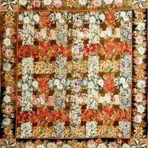 Dense, low-pile square rug featuring multicolored floral sprays of red, white, and blue on a dark brown field.