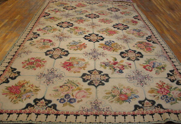 Cream rug featuring framed bouquets of red, pink, and blue flowers connected by dark geometric motifs on wood floor.
