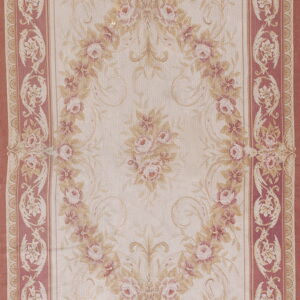 A rectangular rug featuring a detailed floral medallion on a cream field with a wide dusty rose border.