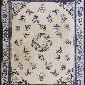 Cream rug with scattered indigo botanical designs and butterflies, surrounded by an intricate multi-layered blue border.
