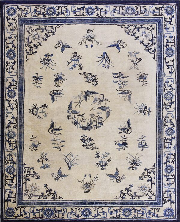 Cream rug with scattered indigo botanical designs and butterflies, surrounded by an intricate multi-layered blue border.