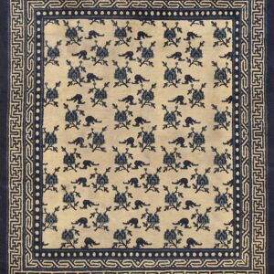 A cream rug features a repeating blue floral and animal pattern, framed by multi-layered geometric and Greek key borders.