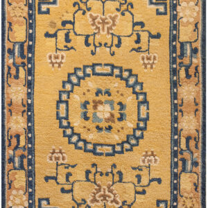 Golden yellow rug featuring a navy blue geometric medallion and coordinating tan and blue patterned borders.