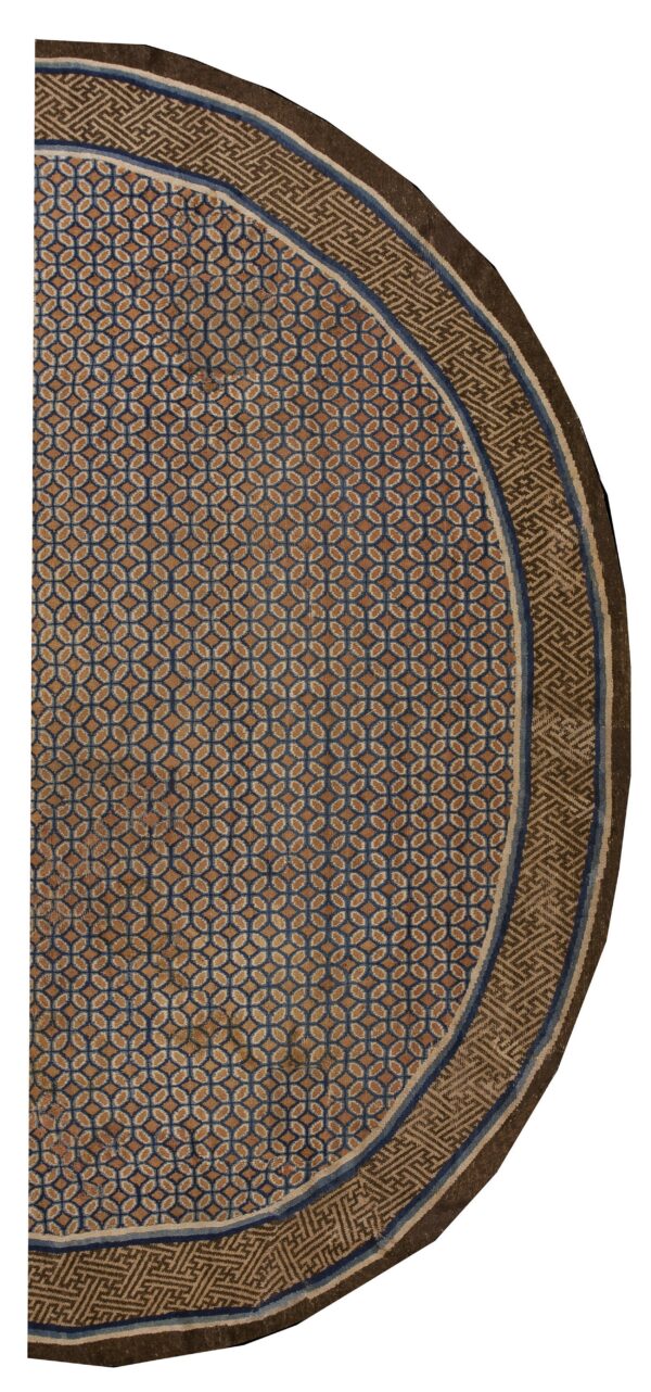 Partial oval rug featuring a blue and brown geometric field surrounded by a complex fretwork border.