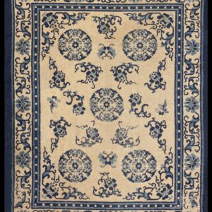 Traditional beige rug with scattered blue floral medallions and an elaborate blue border.