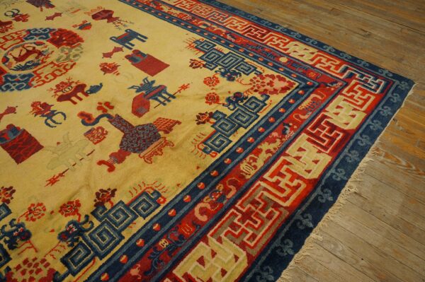 Yellow rug with red and blue symbolic motifs and complex geometric borders on rustic wooden flooring.