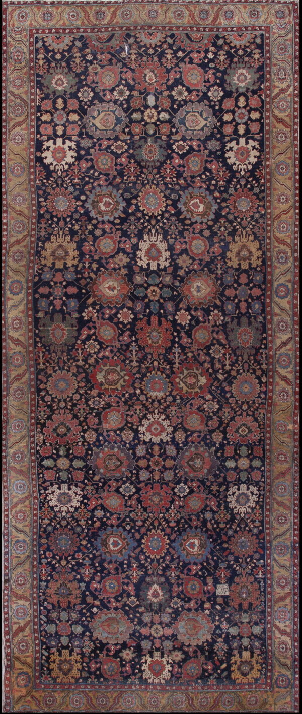 Rectangular rug with a dense traditional pattern in muted red and cream on a dark blue field.