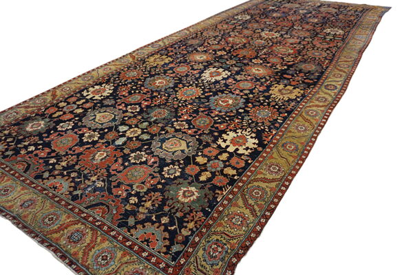 Navy blue runner rug featuring an all-over floral pattern in rust, gold, and green, with an elaborate border.