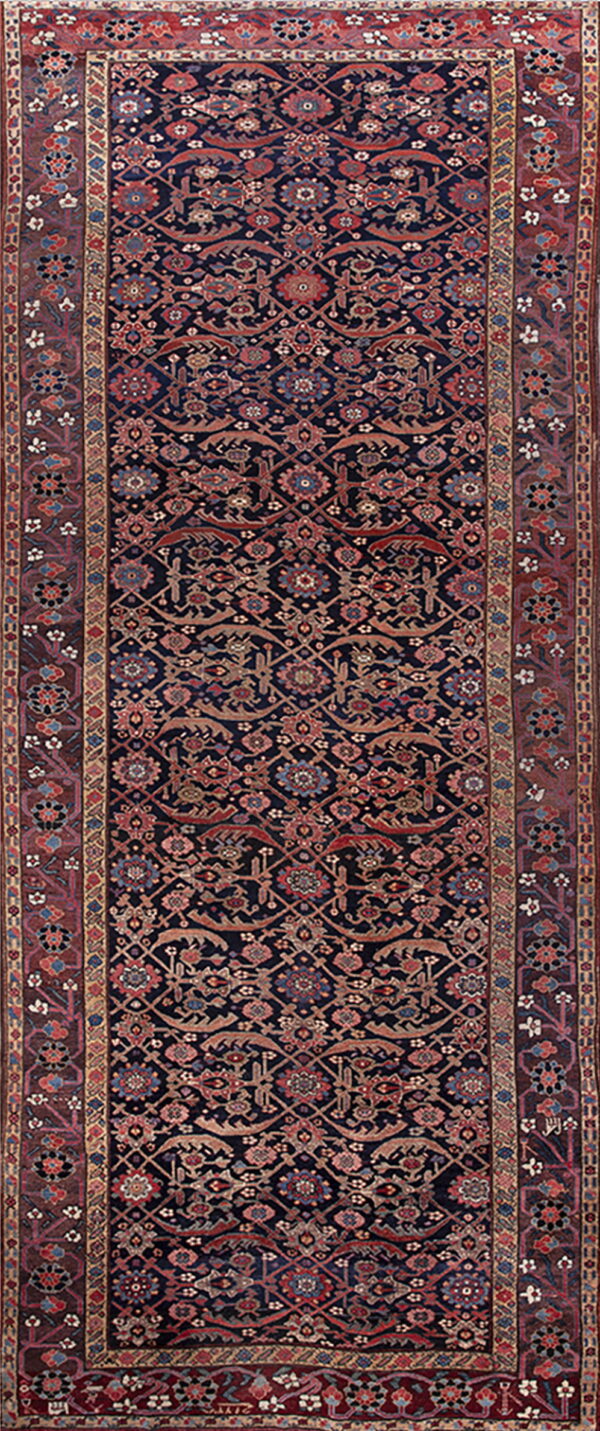 Dark blue runner rug with detailed repeating floral motifs and wide red and brown ornate borders.