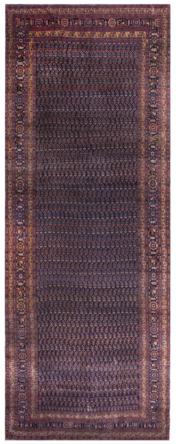 Full view of a dark indigo rug with an all-over teardrop pattern and intricate red and gold borders.