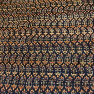 Dark blue rug with repeating traditional boteh patterns in rust, gold, and light blue accents.