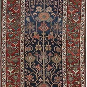 A long runner rug featuring a deep navy blue field with stylized tree-of-life motifs and wide rust red borders.