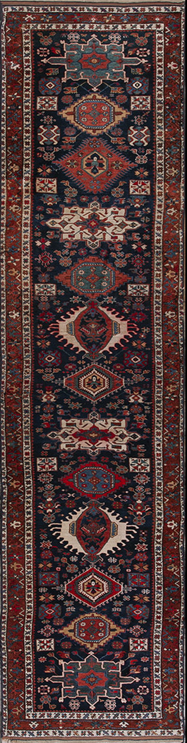 Dark blue runner rug with intricate red, cream, and teal geometric medallions and borders.