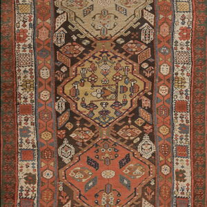 Muted geometric runner rug with repeating rust and tan medallions on a dark brown background.