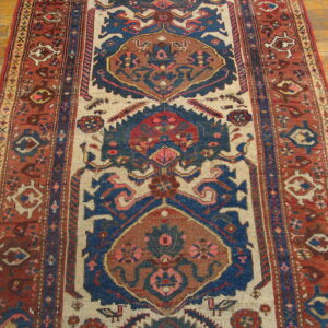 Runner rug featuring red, blue, and cream tribal geometric patterns on light wooden flooring.