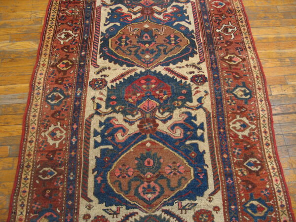 Runner rug featuring red, blue, and cream tribal geometric patterns on light wooden flooring.