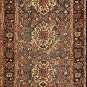 Ornate traditional rug featuring a dark blue field, terracotta motifs, and three cream central medallions with dark borders.