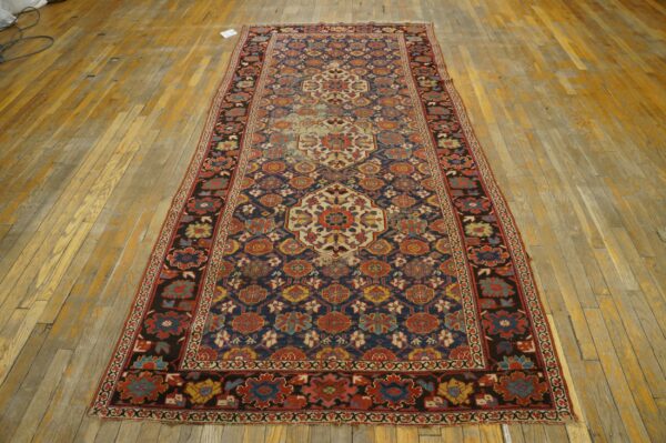 Runner rug featuring intricate medallions in red, blue, and cream on distressed wooden floor planks.