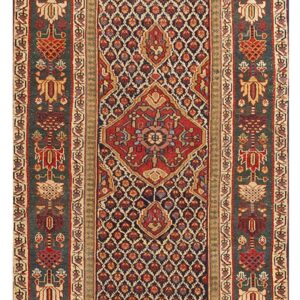 Traditional runner rug with a geometric diamond field and dark green borders featuring stylized red and gold motifs.