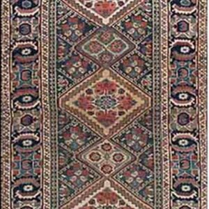 Long geometric runner rug featuring stacked red and navy diamond medallions and complex multicolored borders.