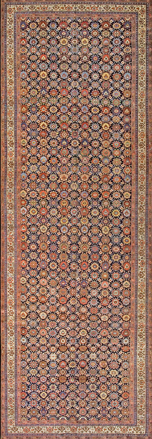 A long runner rug featuring a dark field filled with small, colorful repeating floral and geometric designs.