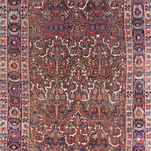 Intricate, low-pile runner rug featuring an all-over repeating pattern in deep maroon, navy, red, and cream.