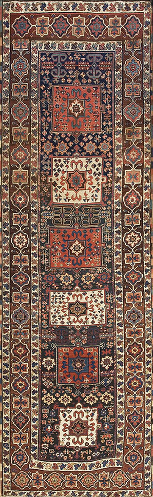 Long runner rug with complex geometric medallions in navy, rust, cream, and brown borders.