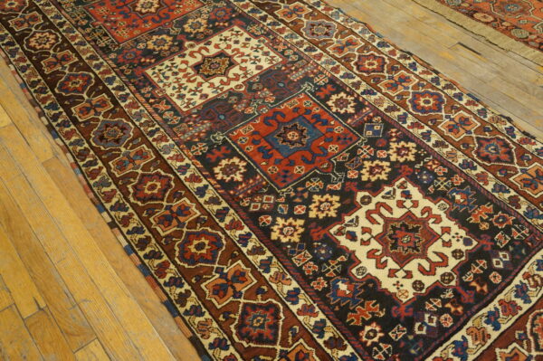 Geometric runner rug in deep red, dark blue, brown, and cream on light wood plank flooring.