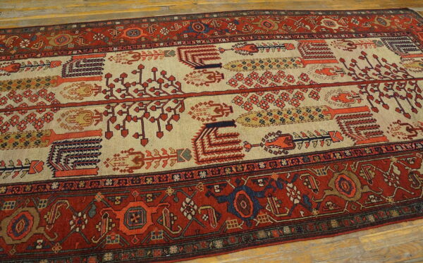 Red and cream runner rug featuring stylized repeating tribal motifs on light wood floors.