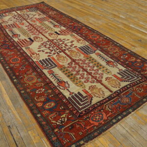 Low pile runner rug with a red border and ivory center featuring geometric motifs on rustic wooden flooring.
