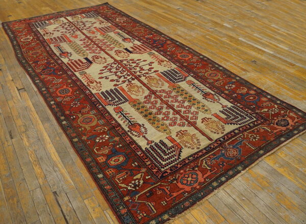 Low pile runner rug with a red border and ivory center featuring geometric motifs on rustic wooden flooring.