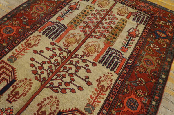 Low-pile rug with a beige center field depicting stylized red and orange trees, surrounded by a dark red border.
