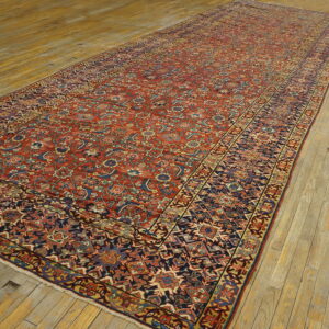Red and navy patterned runner rug featuring geometric and floral motifs is displayed on light wooden flooring.