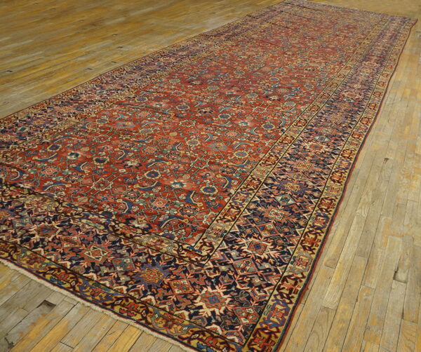 Red and navy patterned runner rug featuring geometric and floral motifs is displayed on light wooden flooring.