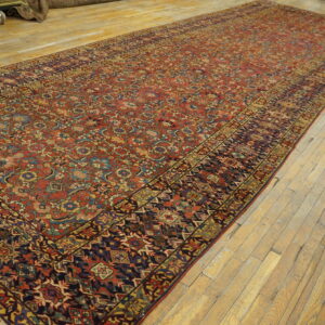 Red runner rug with intricate blue and gold traditional motifs rests on light wood plank flooring.