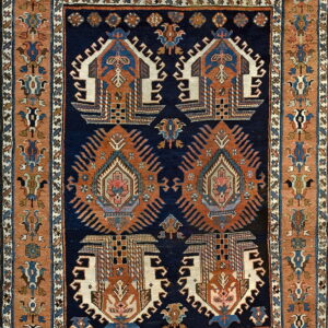 Navy blue rug with rust and cream tribal medallions surrounded by geometric multicolored borders.