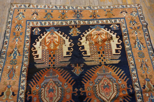 High-pile rug featuring complex geometric motifs in navy, rust, and cream on rustic wooden flooring.