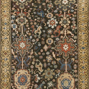 Intricate dark rug featuring colorful stylized medallions and a wide, contrasting gold and tan border.