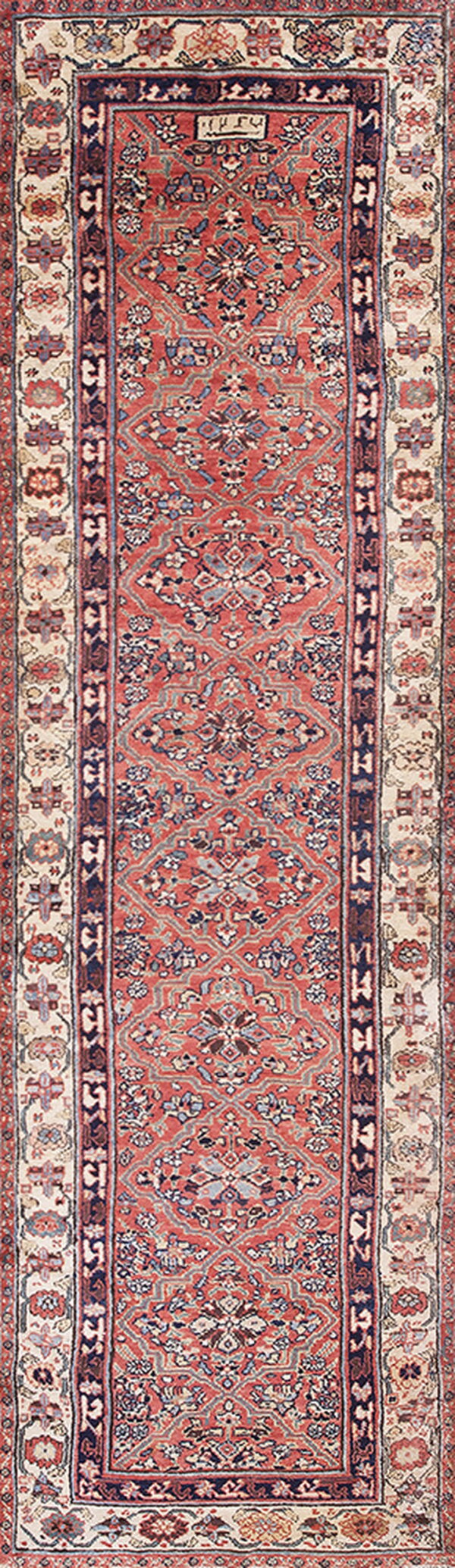 Traditional runner rug featuring a dense medallion design in shades of coral, navy, and ivory.