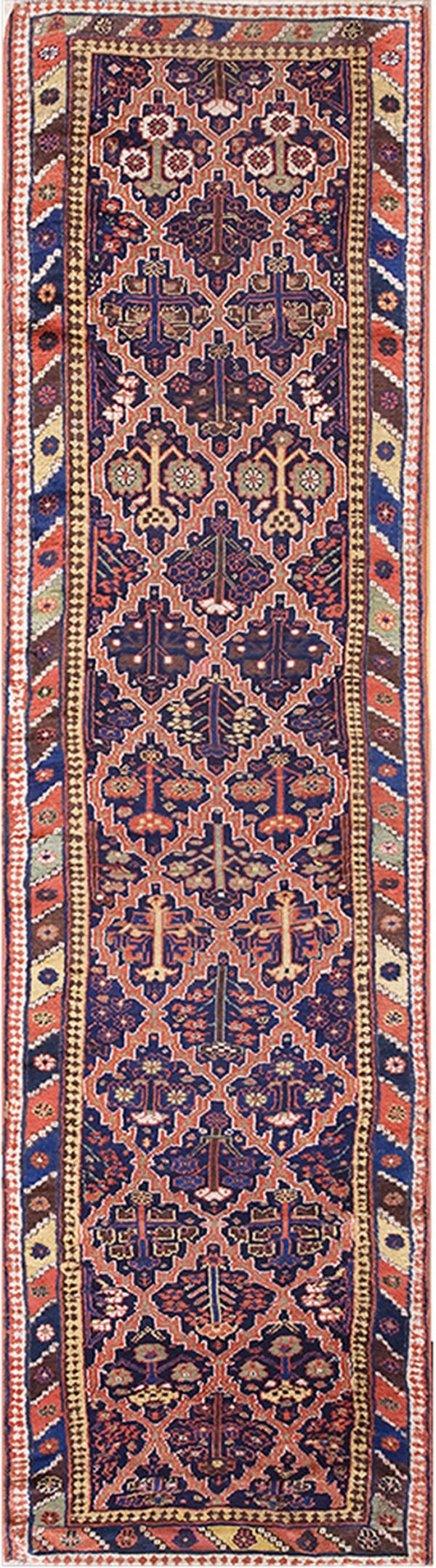 Dark blue and rust runner rug featuring dense repeating geometric and stylized botanical motifs.