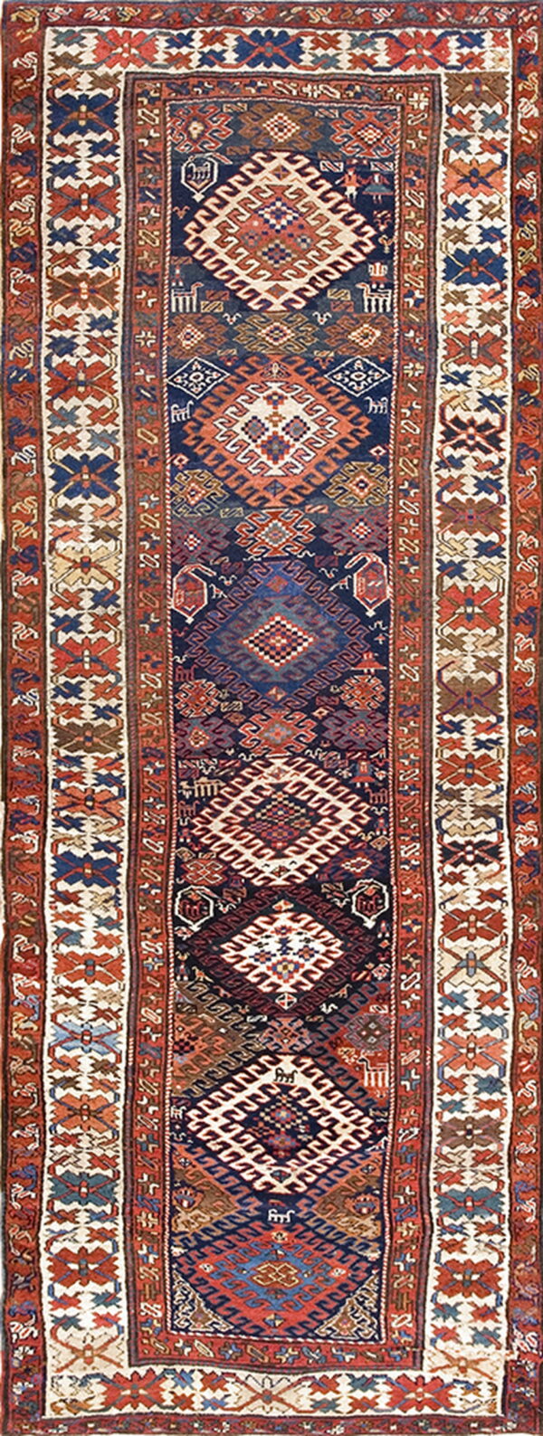 Narrow runner rug featuring repeating tribal geometric patterns in navy blue, rust, cream, and brown.