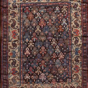 Dark field rug featuring colorful repeating traditional motifs framed by wide beige and brown borders.