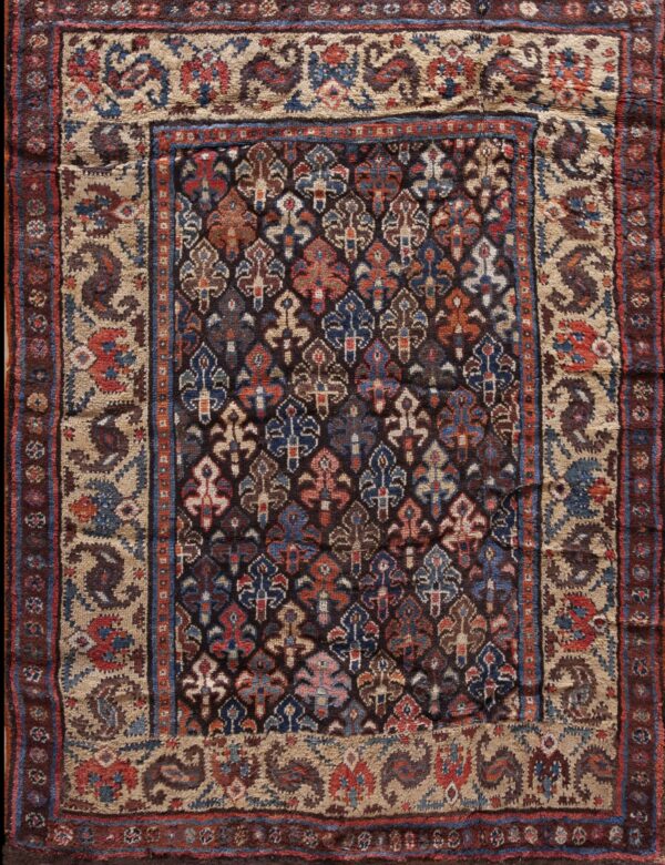 Dark field rug featuring colorful repeating traditional motifs framed by wide beige and brown borders.