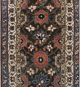 Stylized floral and geometric runner rug with a dark field, red and blue motifs, and a patterned cream border.