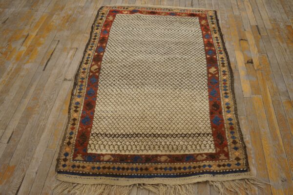 High-pile cream and brown patterned rug with geometric borders rests on distressed wood flooring.