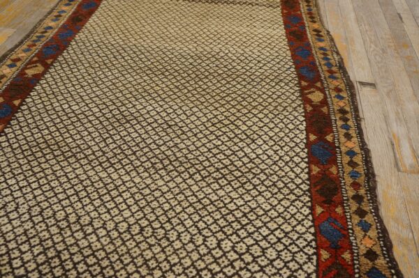 Textured runner featuring small cream and dark brown diamond motifs and colorful borders on light wood flooring.