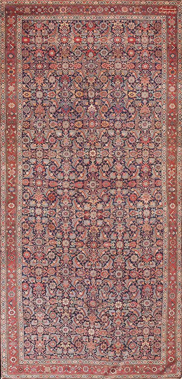 Deep navy rug featuring an intricate all-over botanical and geometric pattern with a wide red border.