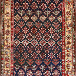 Dark blue runner rug with repeating red and cream stylized motifs and thick geometric borders.